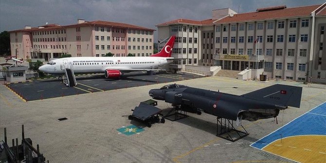 Bahçesinde yolcu ve savaş uçağı olan okul