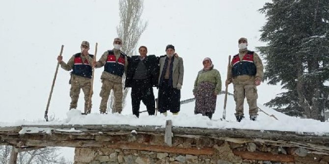 Jandarma, yaşlı adamın çatısındaki karı temizledi