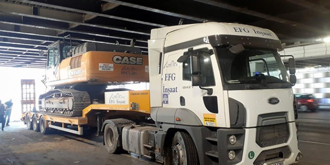 TIR'ın dorsesinde taşınan iş makinesi, alt geçide takıldı