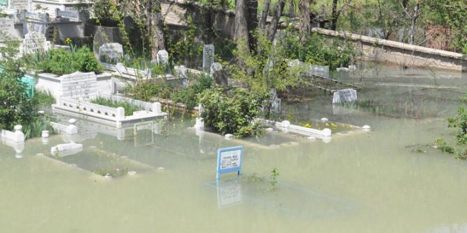 Karların erimesiyle baraj taştı, mezarlık suyla doldu