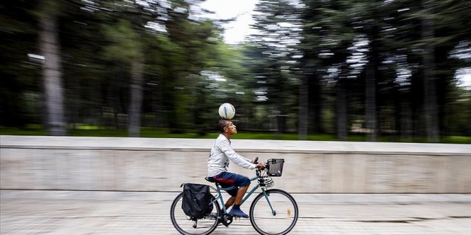 Kafasında futbol topuyla ülke ülke pedal çeviriyor