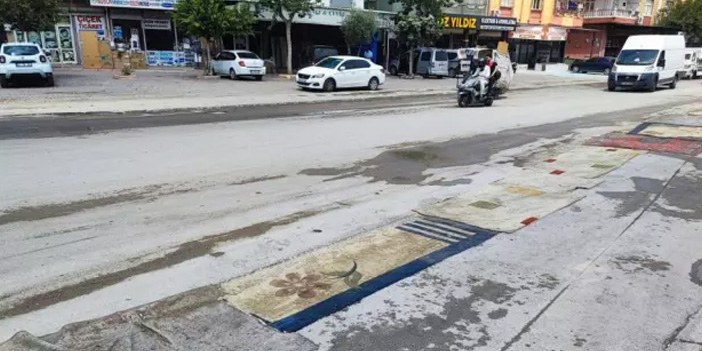 Belediye asfaltlamadı, esnaf yola halı serdi