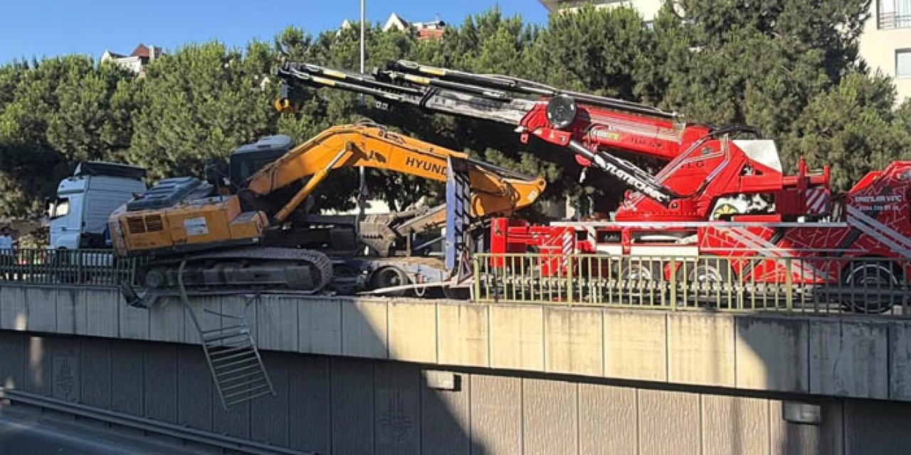 İstanbul’da ilginç kaza: Tırdan düşen ekskavatör korkuluklarda asılı kaldı