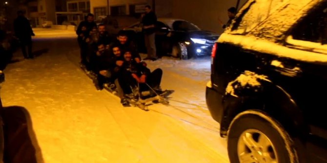 Arabanın arkasına bağladıkları merdivenle karda kaydılar