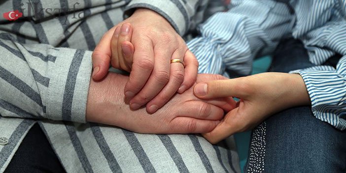 Koruyucu aile yanında kalan bir çocukla el ele tutuşan insan