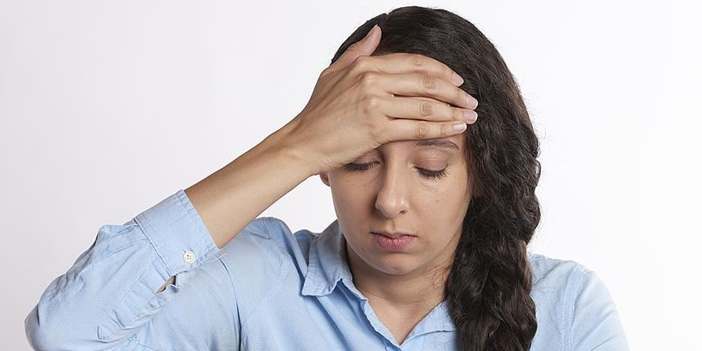 başını tutan kadın