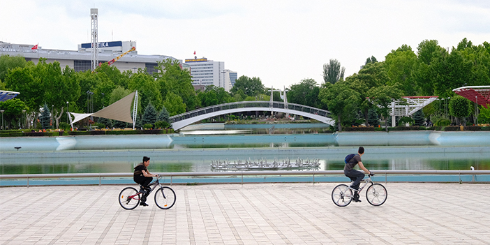 gençlik parkı ve bisiklet süren iki kişi