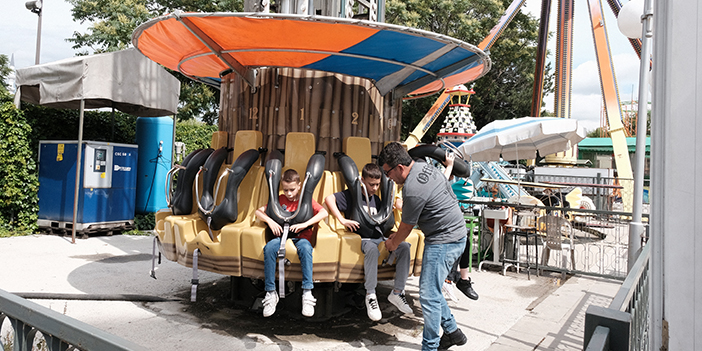 lunaparkta eğlenen 2 çocuk ve görevli